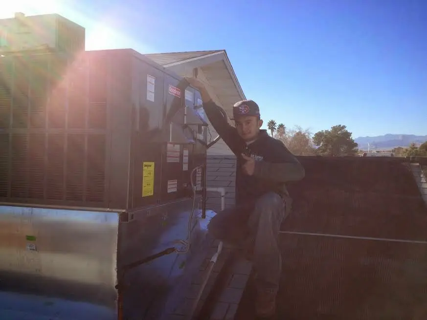 HVAC technician performing Air Duct Repair on a rooftop unit in Nampa